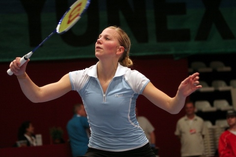 Anu Nieminen in a light blue and white badminton outfit.