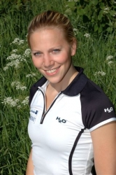 Photo of Anu Nieminen in white and black badminton outfit.
