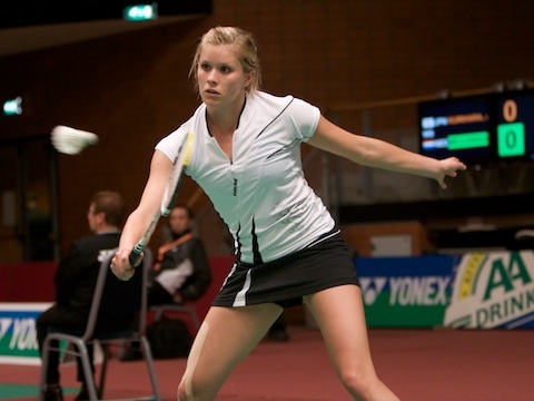 Carola Bott returning badminton shot.